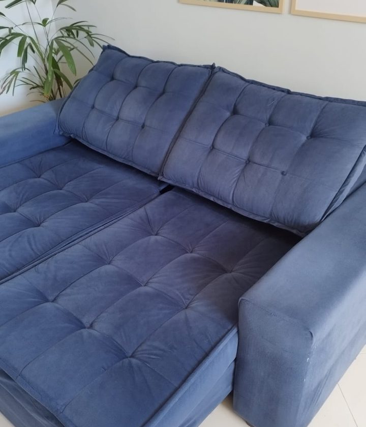 Sofá azul de tecido limpo, em uma sala clara