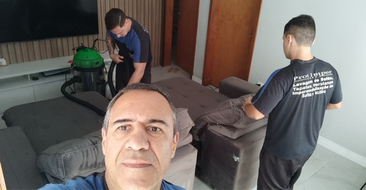 Equipe da PROT IMPER higienizando um sofa retratil a domicilio, com maquina de extracao